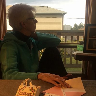 Leslie's silhouette, contemplative, in window at home