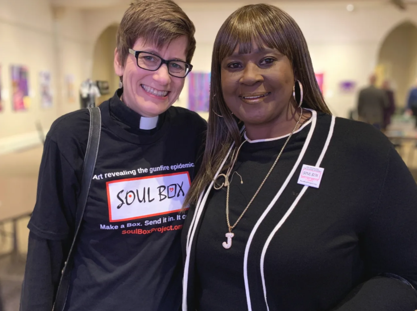 Two people (one a minister) wear a Soul Box shirt or pin