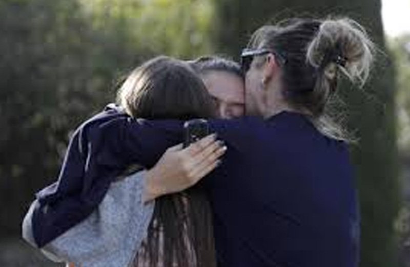 Mom hugging kids after gun violence at a school